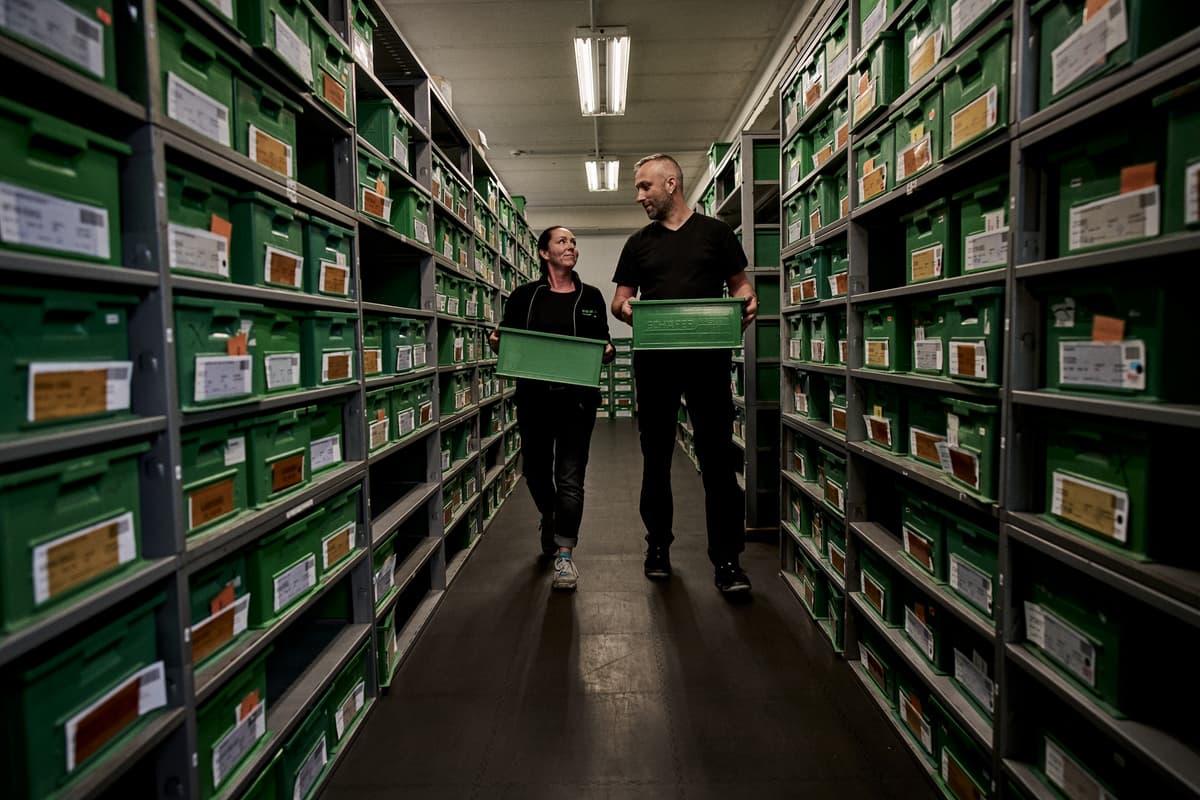 Ein Mann und eine Frau tragen Kisten durch das Lager von Sälzer.